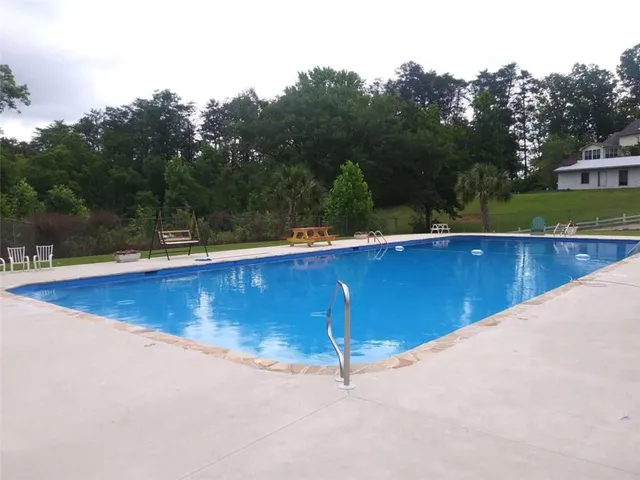 a view of a swimming pool and trees in the background
