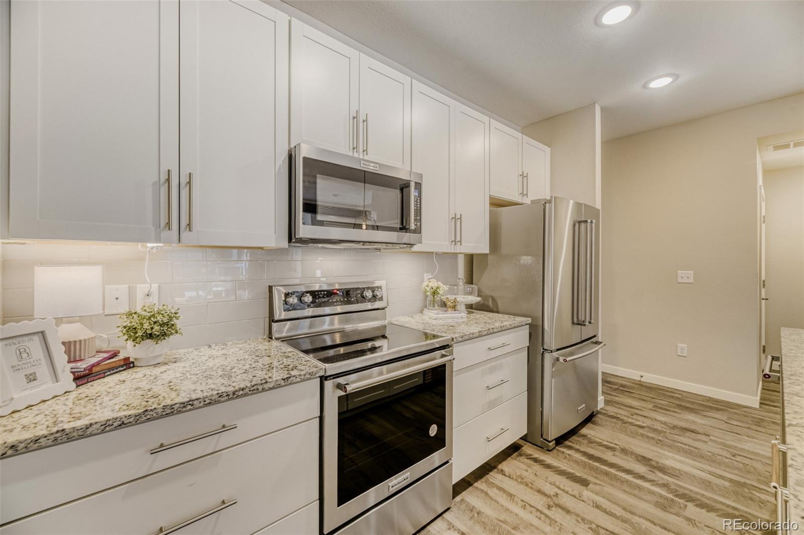 11691 West 45th Place Wheat Ridge, CO 80033 - Photo 11 of 30 a kitchen with granite countertop a refrigerator stove and microwave