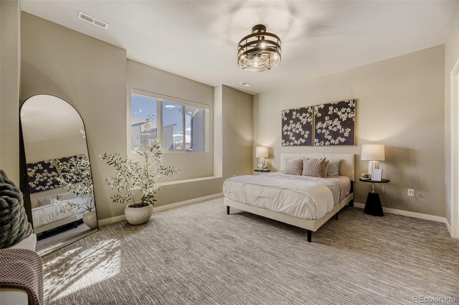 11691 West 45th Place Wheat Ridge, CO 80033 - Photo 13 of 30 a spacious bedroom with a bed and a chandelier