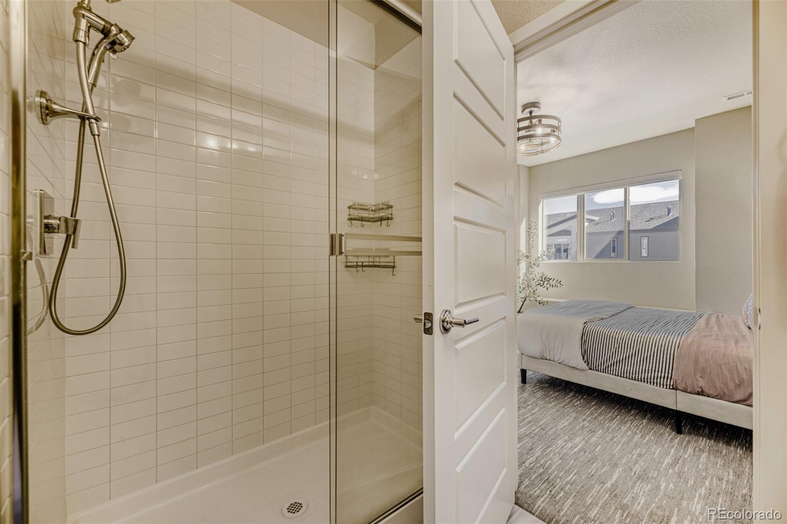 11691 West 45th Place Wheat Ridge, CO 80033 - Photo 16 of 30 a bathroom with a glass shower door