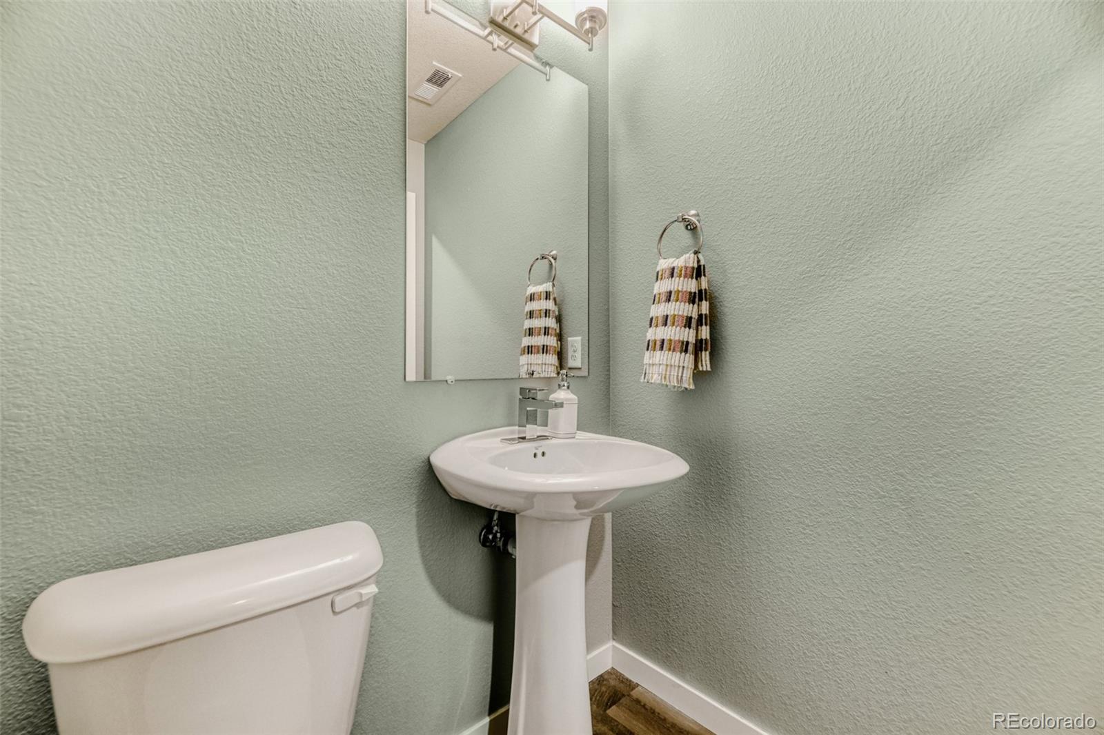 11691 West 45th Place Wheat Ridge, CO 80033 - Photo 23 of 30 a bathroom with a toilet sink and mirror