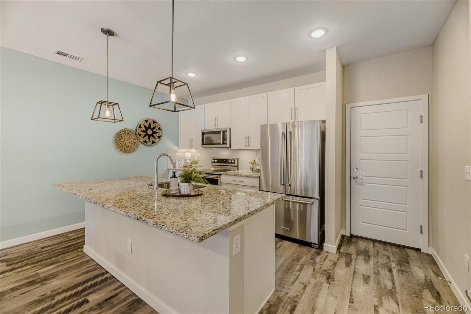 11691 West 45th Place Wheat Ridge, CO 80033 - Photo 10 of 30 a kitchen with kitchen island a counter top space appliances and cabinets