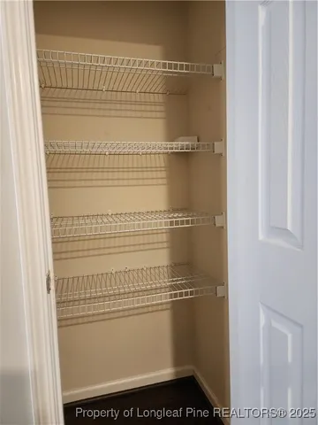 a view of a room with wooden floor and ceiling fan