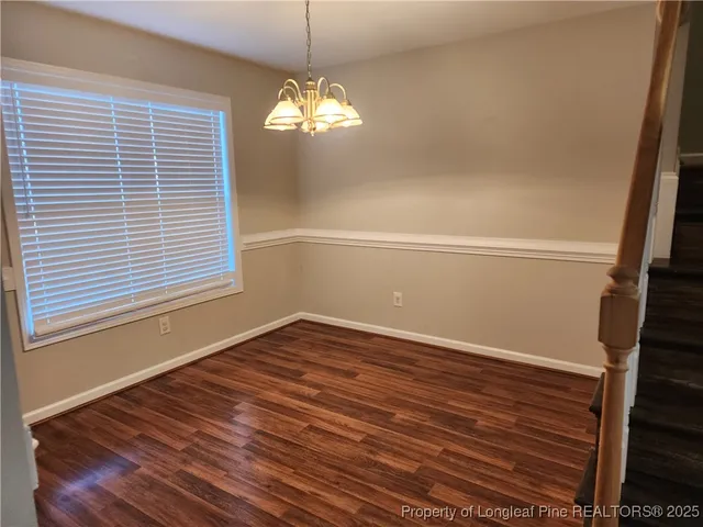 a view of a big room with wooden floor and windows