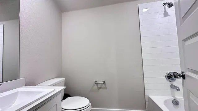 a white toilet sitting next to a bath tub