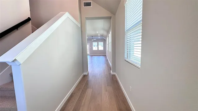 a view of a hallway with wooden floor and staircase