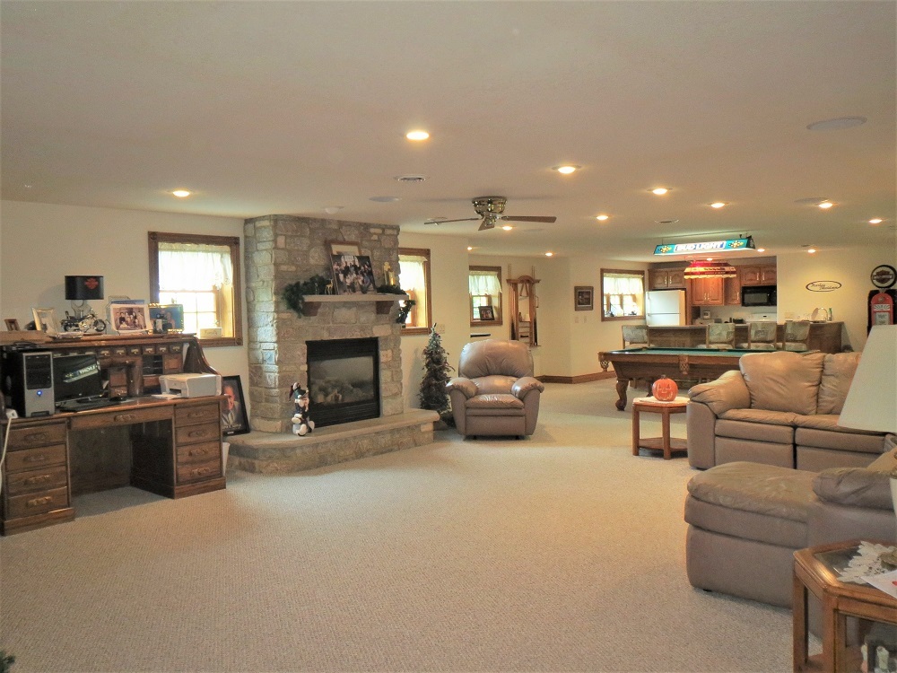 1122 Sterling Road Dixon, IL 61021 - Photo 20 of 45 a living room with furniture a fireplace a flat screen tv and kitchen view