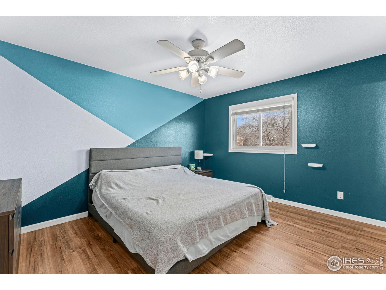 124 Adams Way Firestone, CO 80520 - Photo 12 of 34 a bedroom with a bed and a chandelier