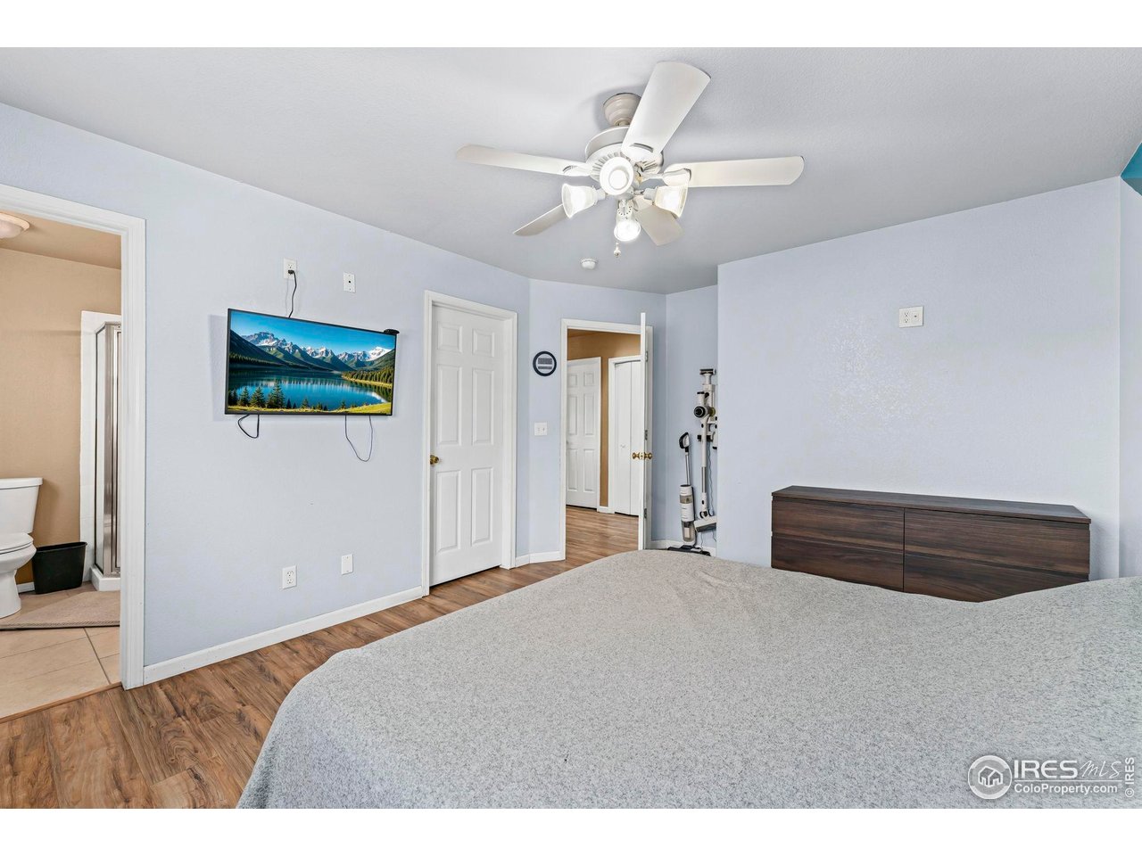 124 Adams Way Firestone, CO 80520 - Photo 13 of 34 a bedroom with a bed and a chandelier
