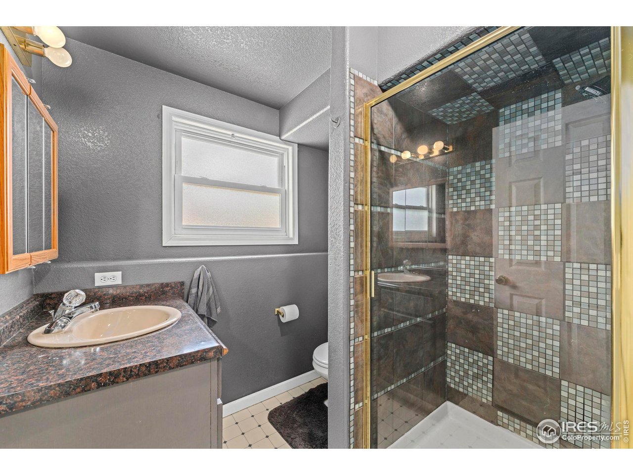 124 Adams Way Firestone, CO 80520 - Photo 23 of 34 a bathroom with a granite countertop sink a mirror and a shower