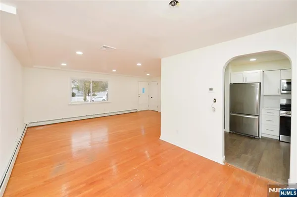 a view of empty room with wooden floor