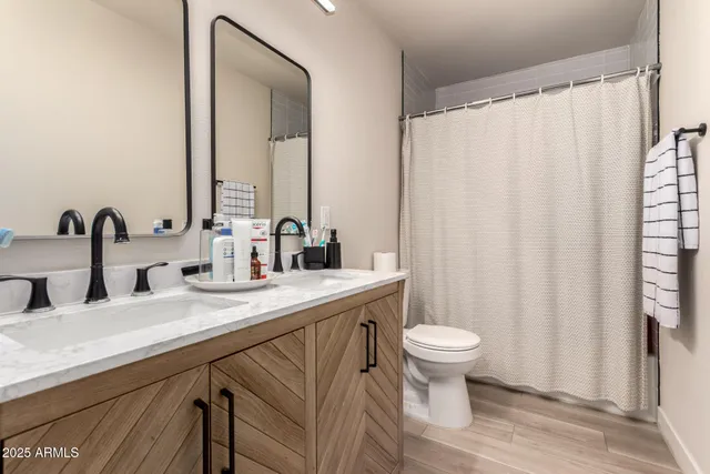 a bathroom with a granite countertop sink a toilet and a mirror