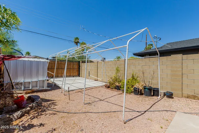 a patio with a table and chairs and potted plants
