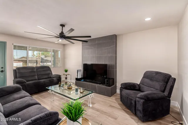 a living room with furniture a flat screen tv and a fireplace