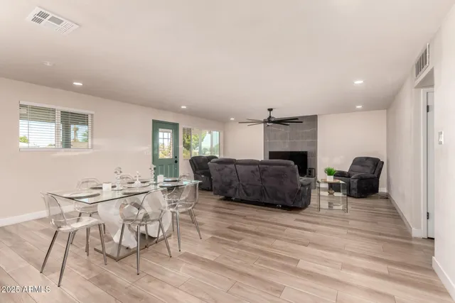 a living room with furniture a ceiling fan and a wooden floor