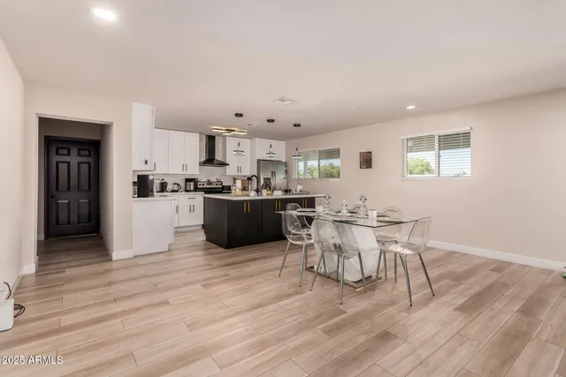 a living room with stainless steel appliances kitchen island granite countertop furniture and wooden floor