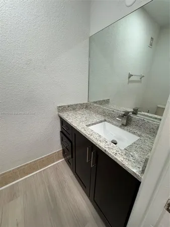 a bathroom with a granite countertop sink and a mirror