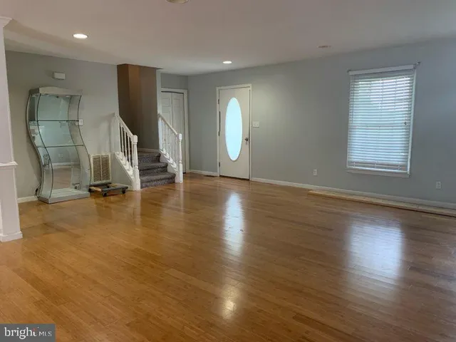 an empty room with wooden floor and a window