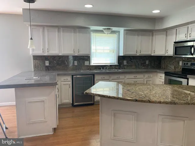 a kitchen with granite countertop white cabinets and a sink