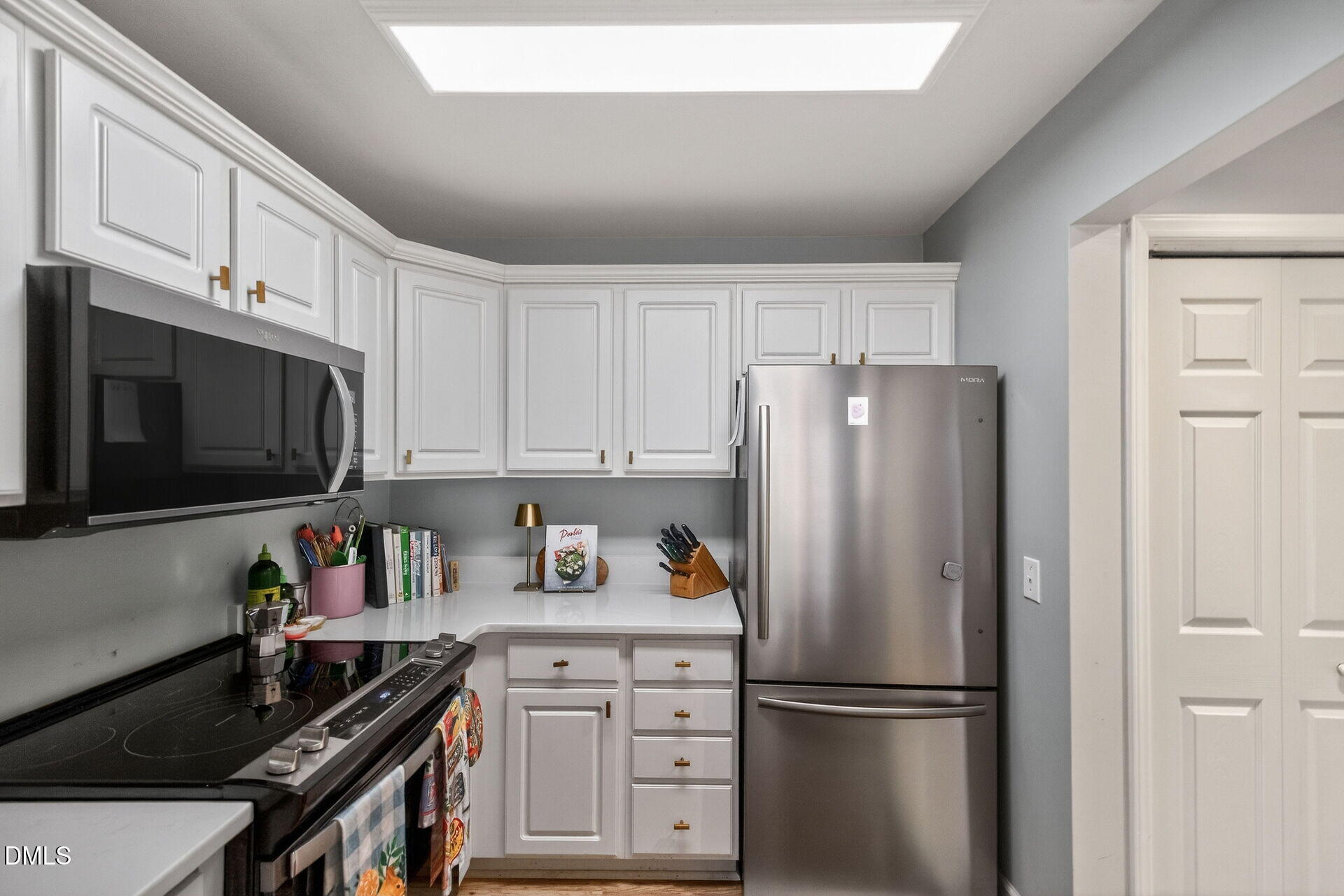 1111 Parkridge Lane, Unit 103 Raleigh, NC 27605 - Photo 14 of 24 a kitchen with stainless steel appliances a refrigerator stove and microwave