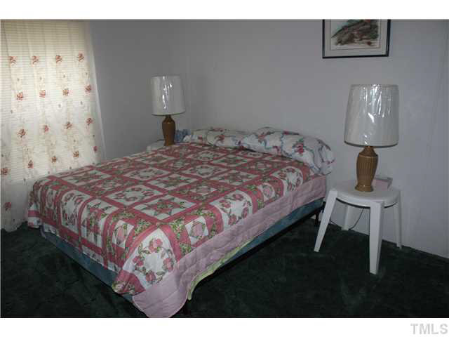 6117 Virgilina Road Roxboro, NC 27574 - Photo 10 of 19 a bedroom with a bed and a lamp on table