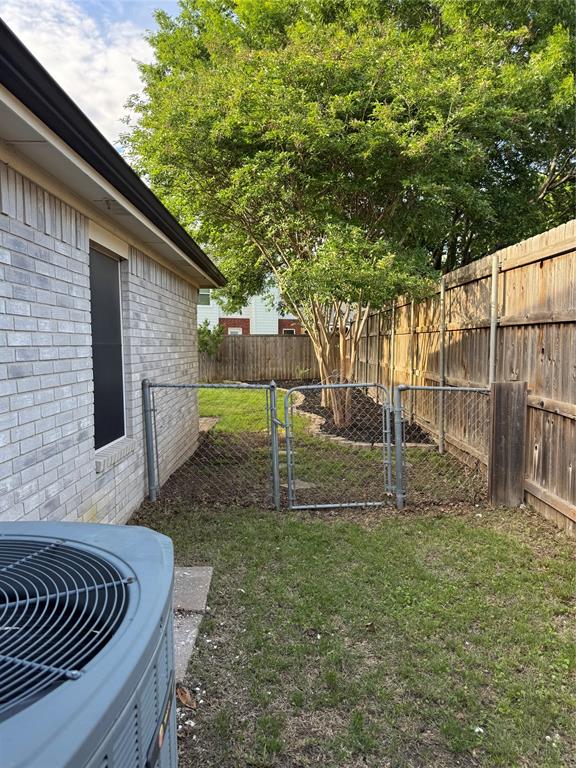 6241 Peach Tree Drive Midlothian, TX 76065 - Photo 15 of 19 Fenced backyard with mature trees, a chain-link gate, and a wood privacy fence