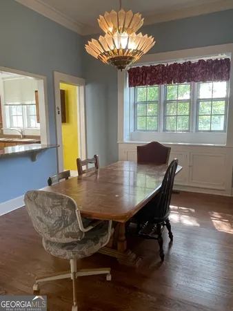 a view of a dining room with furniture a chandelier and wooden floor