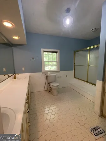 a bathroom with a sink a toilet and mirror
