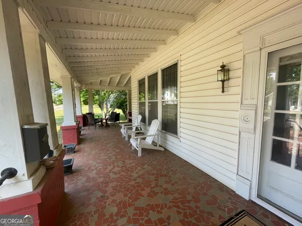 a view of a porch with chairs and potted plants