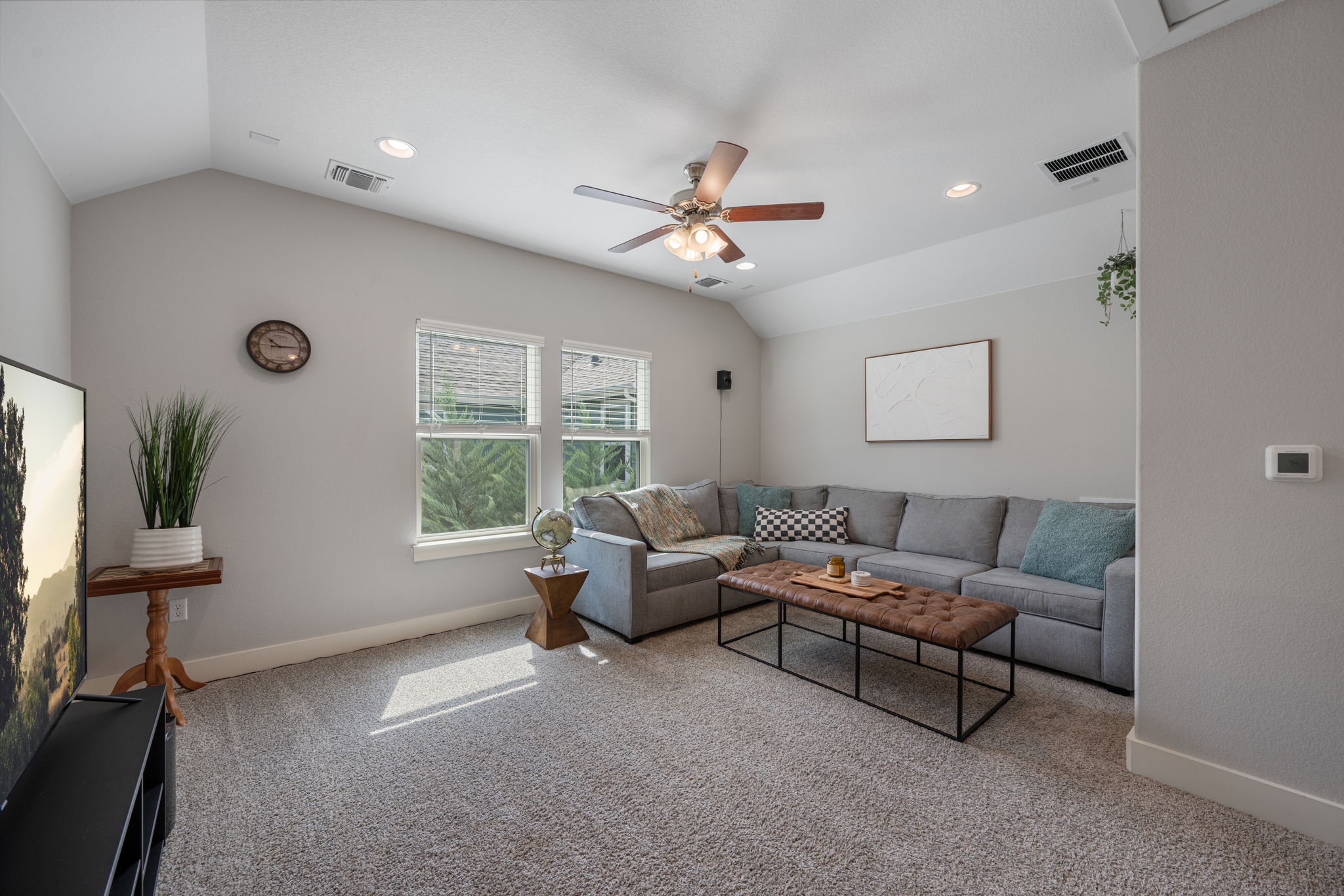 5409 Fox Wing Way Austin, TX 78747 - Photo 15 of 26 Natural light illuminates this living room with a vaulted ceiling and inviting carpeted floors.