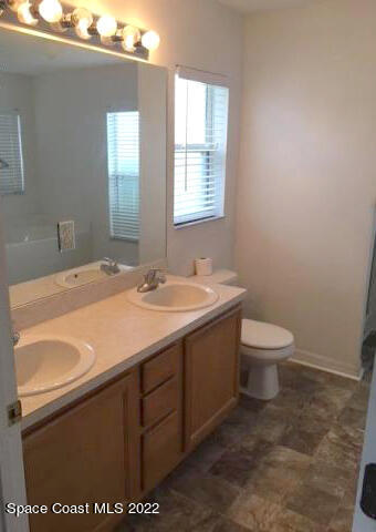 3312 Merrick Avenue Rockledge, FL 32955 - Photo 13 of 30 a bathroom with a sink a toilet and mirror