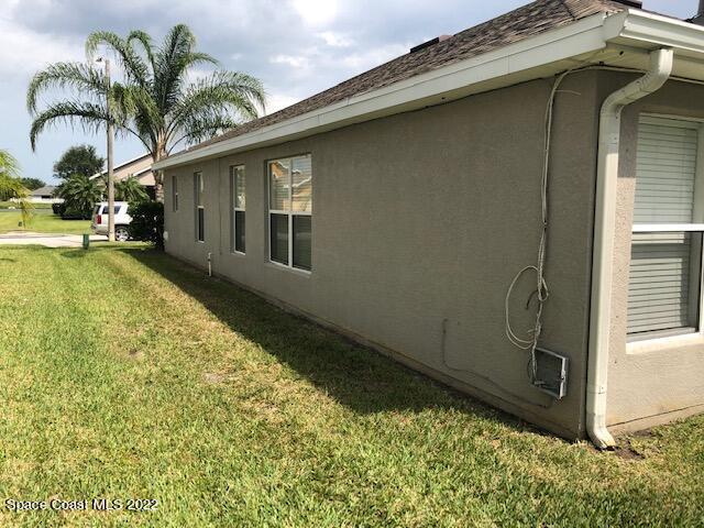 3312 Merrick Avenue Rockledge, FL 32955 - Photo 26 of 30 a backyard of a house with potted plants and palm tree