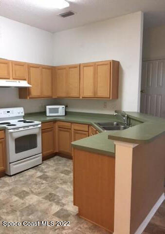 3312 Merrick Avenue Rockledge, FL 32955 - Photo 7 of 30 a kitchen with a sink stove and cabinets