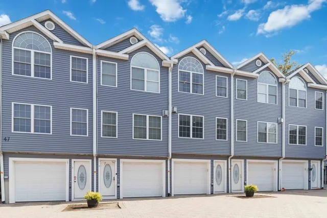 a view of a brick house with many windows next to a road