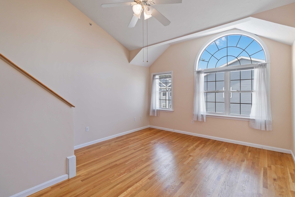 47 Alder Street, Unit 6 Waltham, MA 02453 - Photo 18 of 34 an empty room with wooden floor chandelier fan and windows