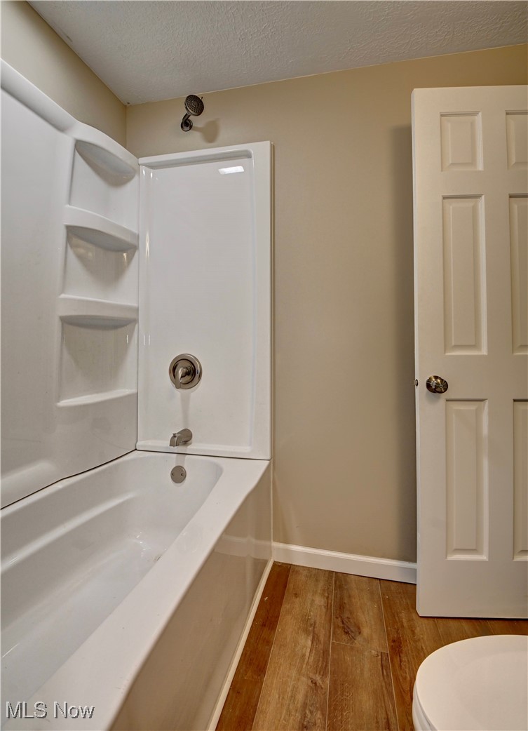 4624 Ridge Avenue Southeast Canton, OH 44707 - Photo 20 of 48 Full bathroom featuring a textured ceiling, light wood-type flooring, and shower / washtub combination