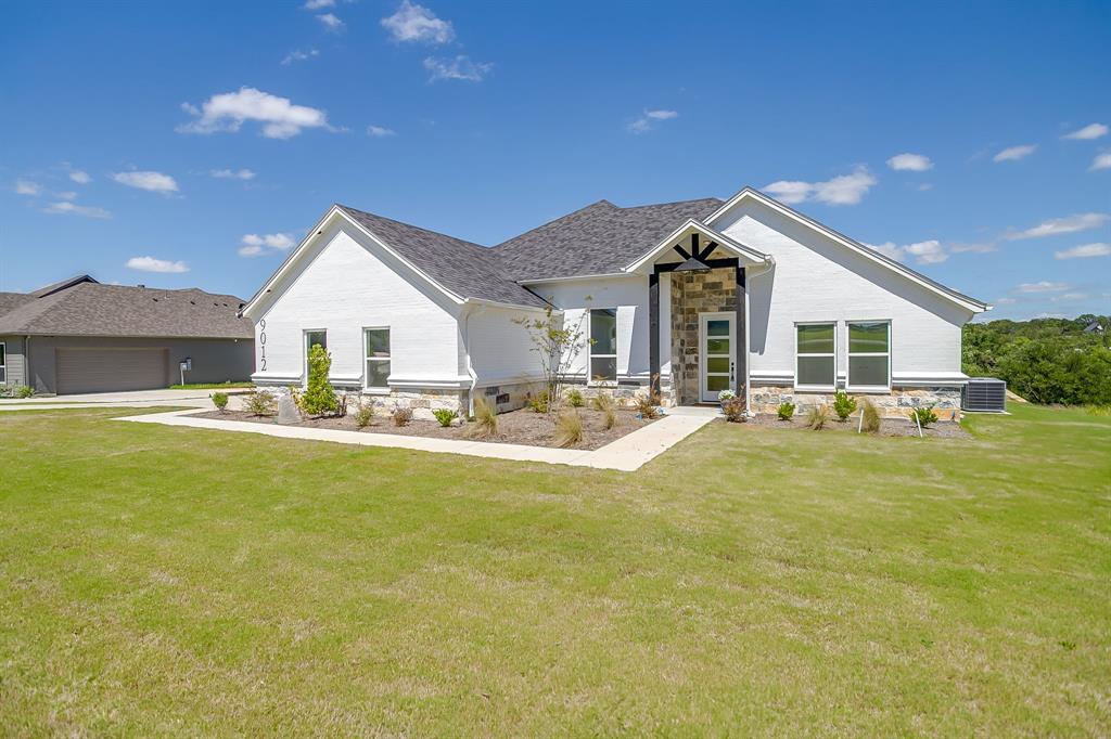 9012 Valley Oak Court Springtown, TX 76082 - Photo 4 of 40 a view of a white house with a big yard and potted plants