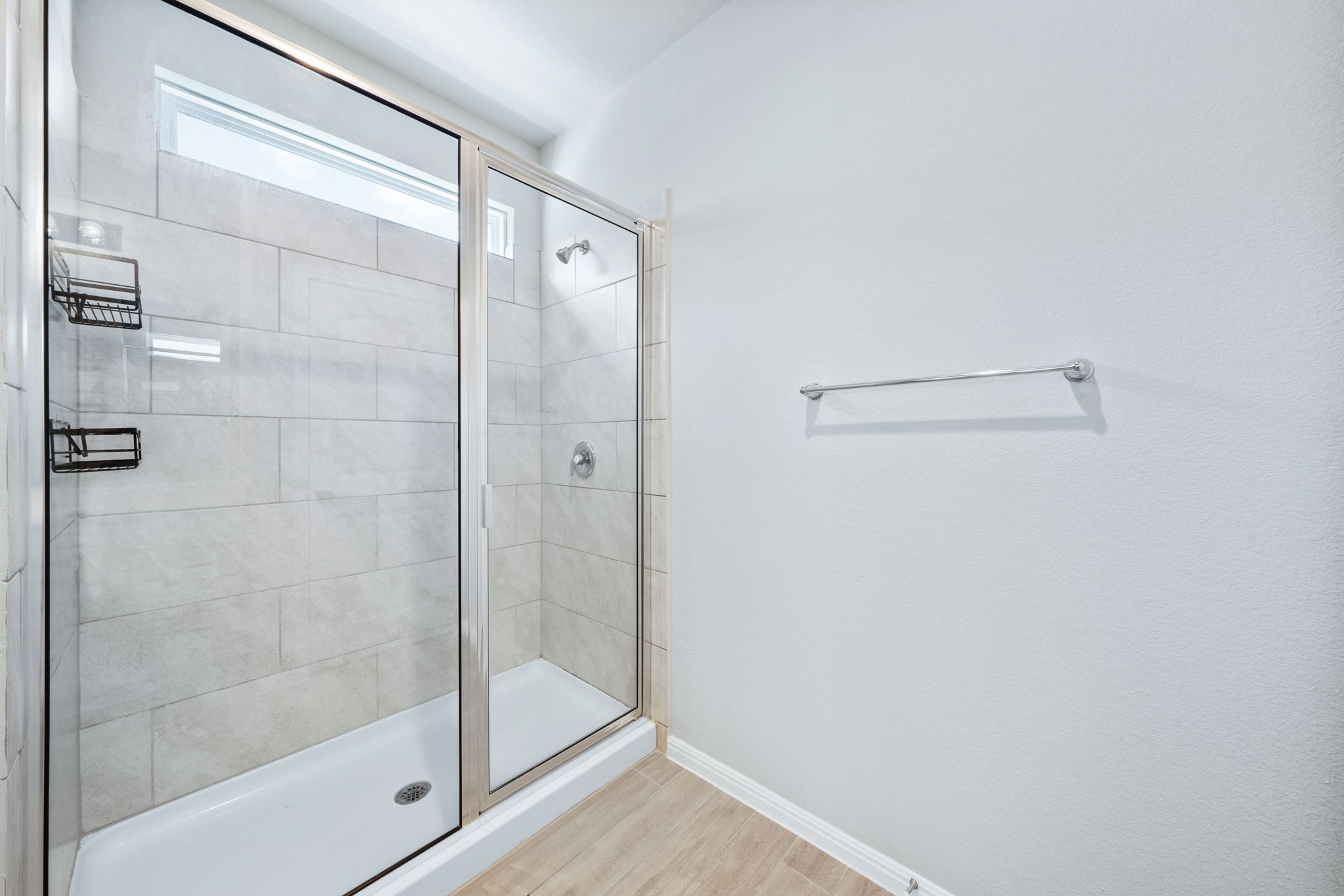 2412 Starhill Ranch Street Georgetown, TX 78628 - Photo 28 of 40 A well-appointed shower stall features clear glass doors and a transom window for natural light.