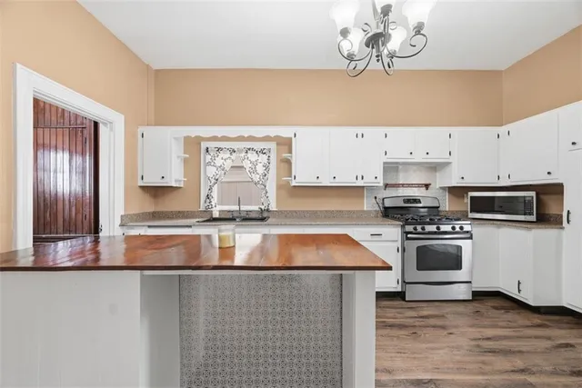 a kitchen with stainless steel appliances granite countertop a sink a stove a microwave and cabinets