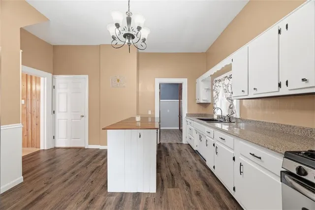 a large kitchen with cabinets wooden floor and stainless steel appliances