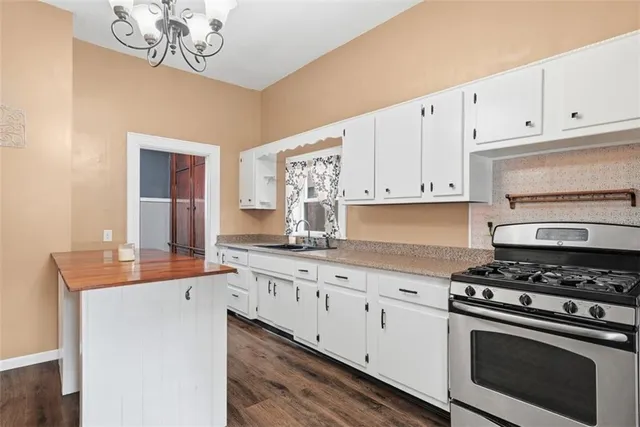 a kitchen with granite countertop white cabinets and stainless steel appliances
