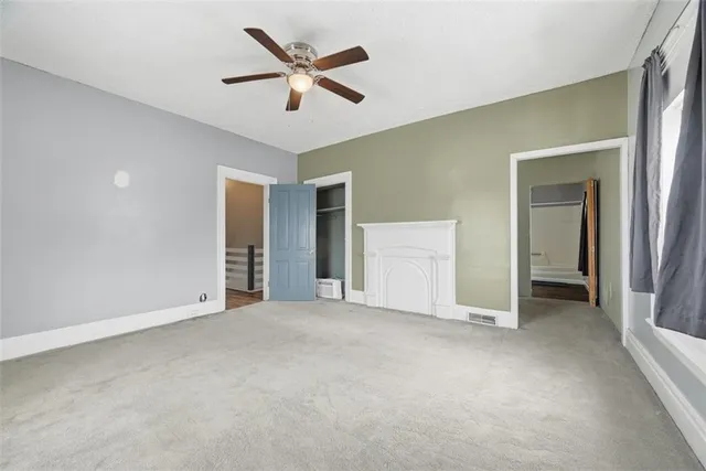 an empty room with closet and windows