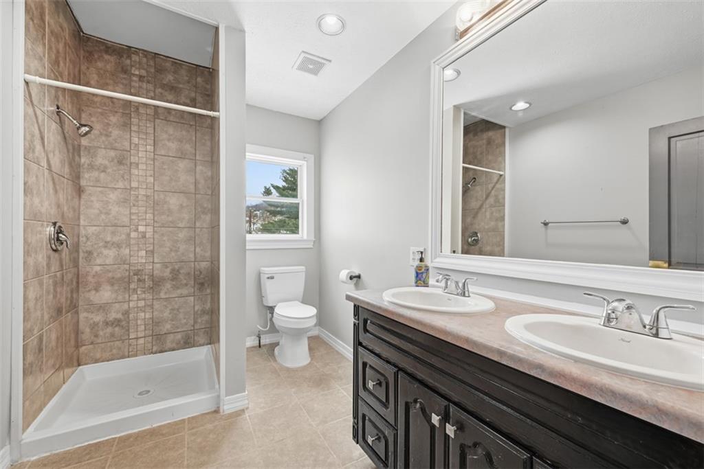 901 4th Avenue Freedom, PA 15042 - Photo 32 of 49 a bathroom with a granite countertop sink a toilet a mirror and shower