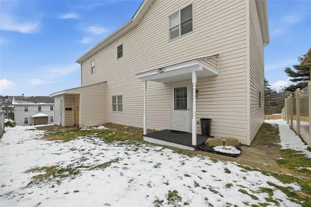 a view of a white house with wooden fence