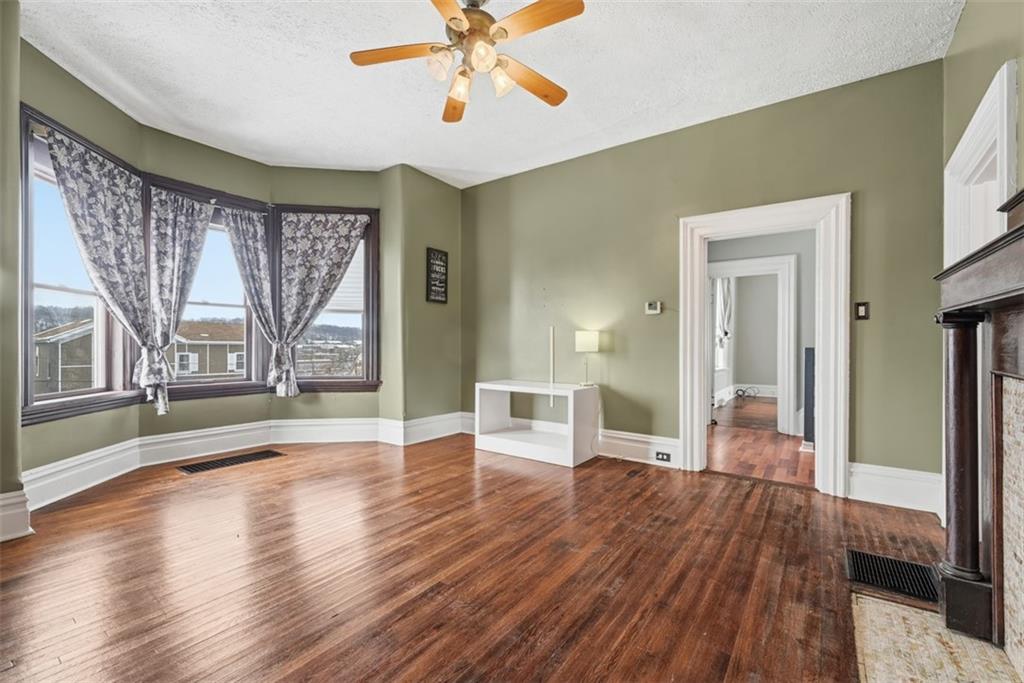 901 4th Avenue Freedom, PA 15042 - Photo 5 of 49 a view of a livingroom with wooden floor a ceiling fan and windows