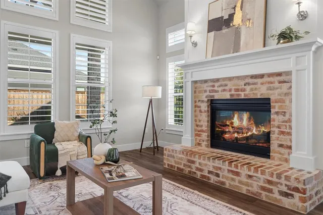 a living room with furniture a fireplace and a floor to ceiling window