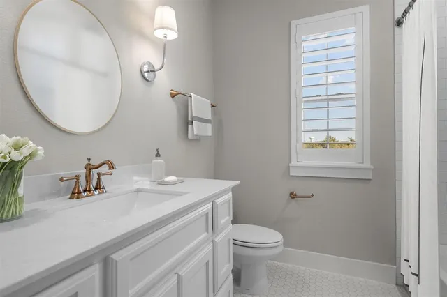 a bathroom with a sink a toilet and a mirror