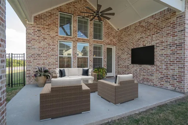 a view of a patio with couches chairs and a flat screen tv