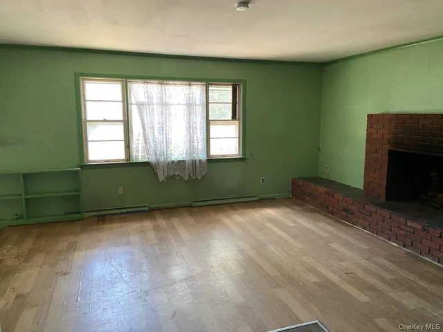 a view of an empty room with a fireplace and a window