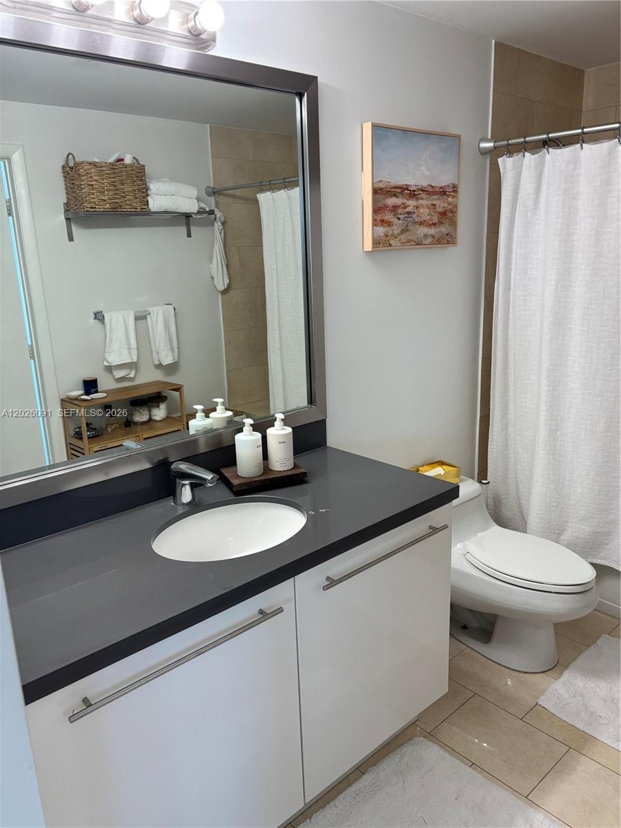 90 Southwest 3rd Street, Unit 1705 Miami, FL 33130 - Photo 10 of 33 a bathroom with a granite countertop sink and a mirror
